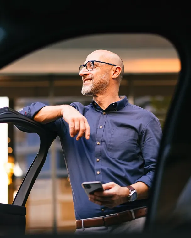 man waiting by open car door